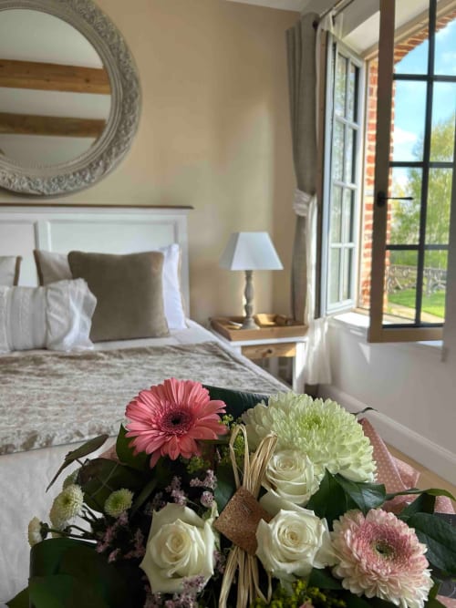 Grande chambre d'hôtes de couleurs blanches et lin. Lin culture locale. Séjour radieux au Clos Mahiel avec sa salle de bain privée et parking privé. Vue sur le jardin. 