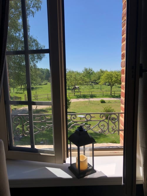 Vue pittoresque du jardin depuis la Chambre Aurore-Lin au Clos Mahiel, Saint-Romain-de-Colbosc, avec balcon ornementé surplombant