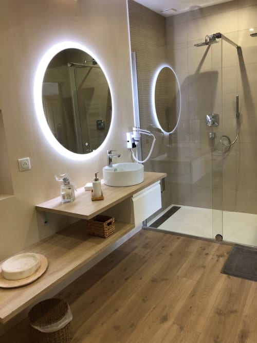 Salle de bain moderne du Clos Mahiel avec miroirs ovales éclairés LED, vasque blanche circulaire et douche vitrée à l'italienne
