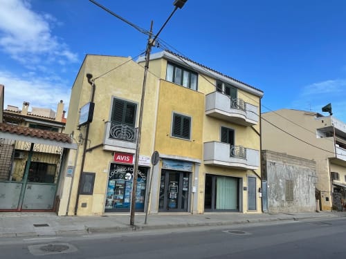 Yellow apartment building with street-level shop in Orosei, Italy - Loddo Paola property manager location