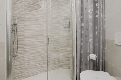 Modernes Badezimmer mit begehbarer Dusche, Streifenfliesen, Glaswand und Duschvorhang in der Residenza la Pietra, Pietra