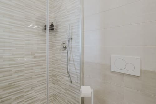 Modernes Duschbad mit gestreiften Fliesenwänden in der Wohnung Pietra - Verde im Residenza la Pietra, Ligurien