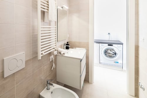 Modernes Badezimmer mit Waschbecken, Handtuchhalter und integrierter Waschmaschine in der Residenza la Pietra, Pietra Ligure