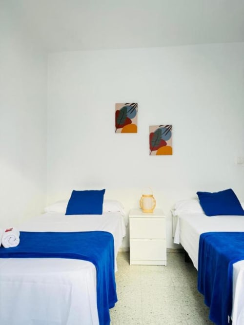 Dormitorio doble en Apartamentos Rocamar, Santa Cruz de la Palma, con detalles azules y obra moderna