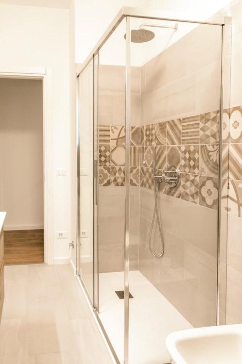 Modern glass shower enclosure with decorative tile accents in Ca' Martha apartment bathroom, Treviso