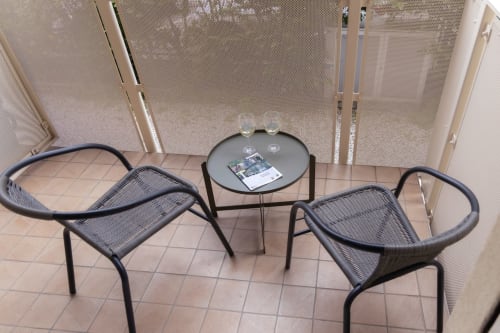 Outdoor seating area at Ca' Martha apartment with two wicker chairs and small round table on tiled patio