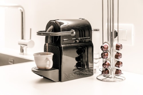 Macchina da caffè Nespresso con tazza bianca e porta capsule nella cucina di un appartamento a Treviso