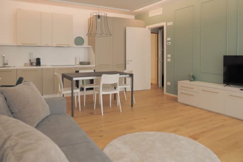 Zona living e pranzo moderna a Treviso con cucina, tavolo da pranzo, divano, TV e parquet