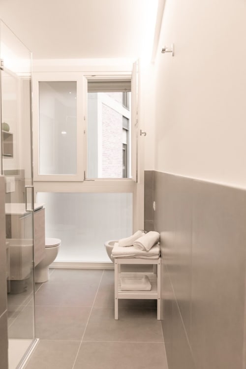 Bagno moderno presso Treviso Stays con doccia walk-in, wc e asciugamani bianchi nell'appartamento Ca' Borsa, Treviso.