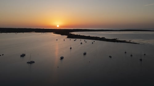 Atardecer en el puerto de La Savina con veleros amarrados y aguas tranquilas, vista marina de Formentera
