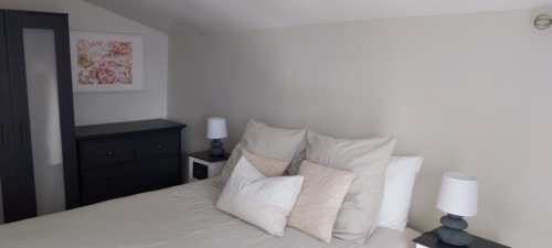 Cozy bedroom at La Crèche cottage in La Barrat, Monmarvès, featuring a bed with white pillows and black nightstands