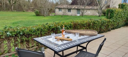 Outdoor patio at La Barrat cottage in Monmarvès with dining table, chairs, and manicured grounds