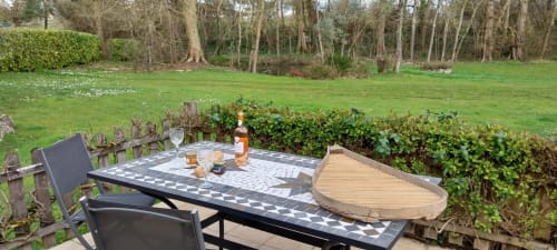 Outdoor dining setup at La Barrat cottage in Monmarvès with patterned table, chairs, and garden views