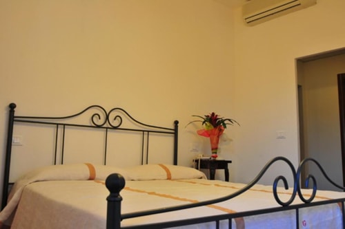 Wrought iron double bed with cream bedding at Il Casale di Nanni B&B in Lucca, Italy