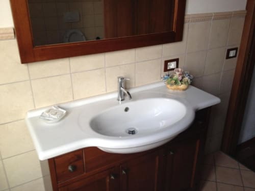Bathroom sink with white basin, chrome faucet, and wooden vanity at Il Casale di Nanni bed and breakfast in Lucca, Italy
