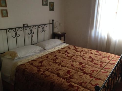Double bedroom at Il Casale di Nanni B&B in Lucca with wrought iron bed frame and burgundy damask bedding