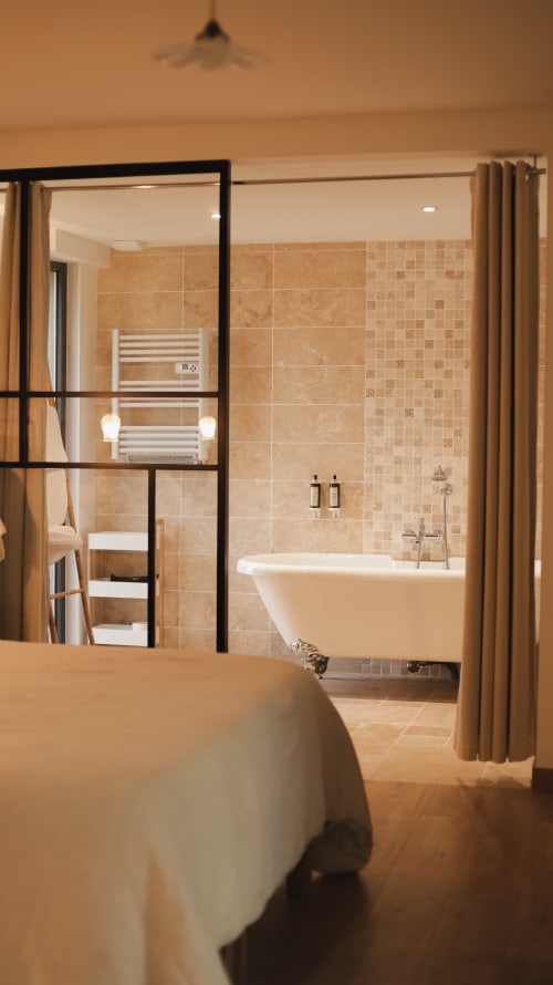 Bedroom view to bathroom with black-framed glass