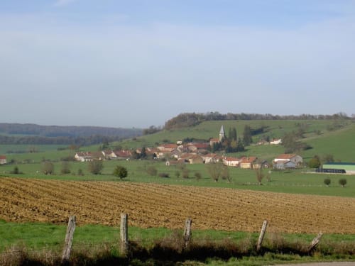 Village rural français de Doncourt-sur-Meuse avec église, niché dans des collines verdoyantes et des terres agricoles