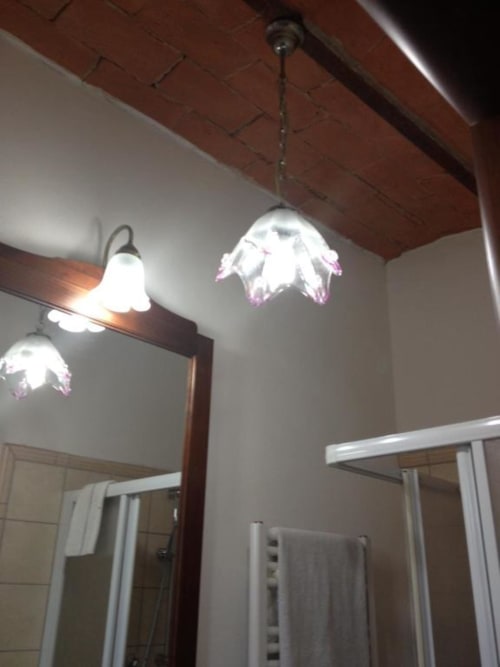 Bathroom ceiling fixture with white petal-shaped lights and pink accents at Il Casale di Nanni, Lucca