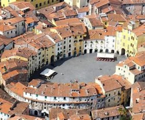 Aerial view of Lucca's historic Piazza Anfiteatro with medieval buildings and terracotta roofs surrounding the circular plaza