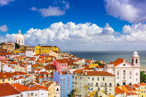Bairro colorido de Lisboa com telhados de terracota, igrejas históricas e vistas do Rio Tejo perto do Jardim Real do Príncipe