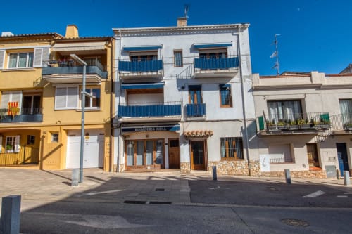 Colorful residential buildings with blue balconies in Palafrugell town square, Calella
