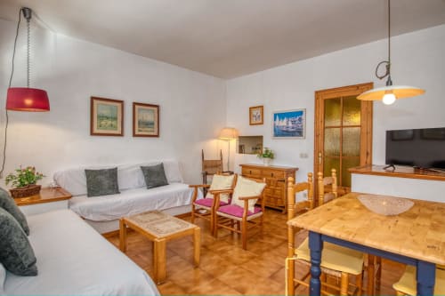 Bright studio apartment in Calella with comfortable seating, wooden furniture, and modern amenities including TV and kitchen