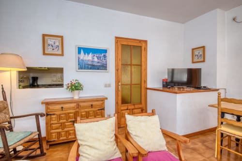 Cozy studio apartment in Calella with wooden furniture, TV, kitchen area, and city view in Palafrugell