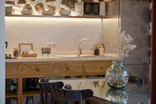 Modern kitchen and dining area at La Cochera cottage in Finca de La Geria, Yaiza, with wooden cabinets and white countertops