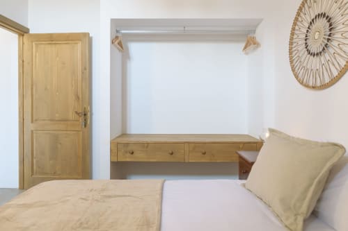 Wooden bedroom in La Cochera cottage at Finca de La Geria with bed, desk, door, and circular wall decoration