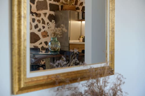 Mirror reflection of La Cochera cottage interior at Finca de La Geria, showing dried flowers in glass vase and modern kitchen