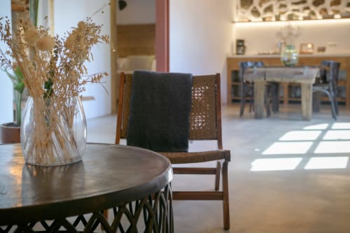 Modern cottage interior at Finca de La Geria with round table, dried flowers, wooden chairs, and bright dining area in Yaiza