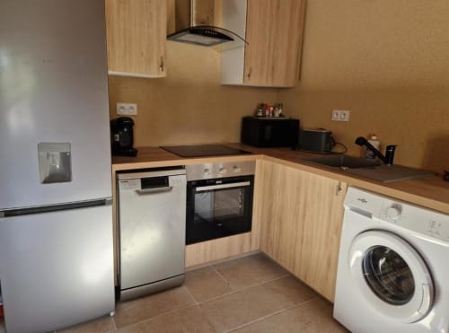 Cuisine moderne du gîte Escapade au Domaine de la Grande Décision, La Douze, avec meubles en bois, appareils et