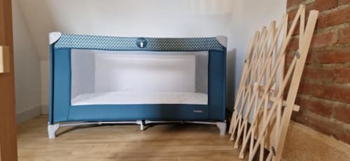 Blue portable travel cot with white bedding in Gîte Cocoon cottage at Domaine de la Grande Décision