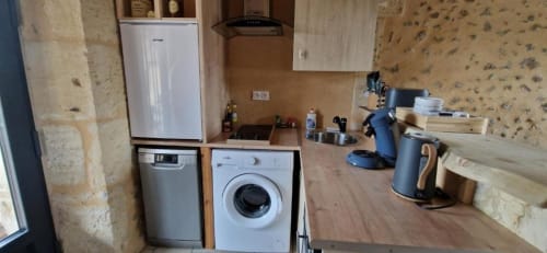Compact kitchen in Gîte Cocoon cottage at Domaine de la Grande Décision with white appliances, washing machine, and