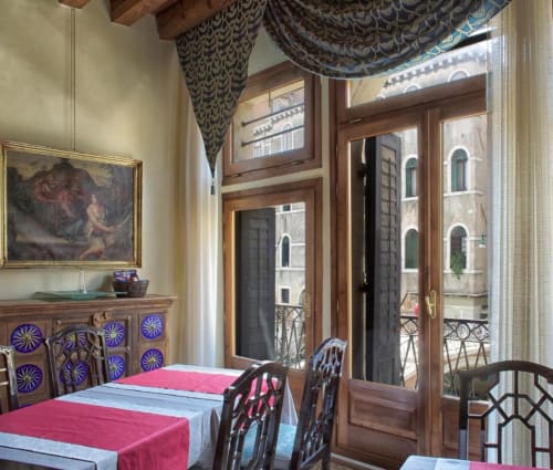Elegante sala da pranzo del Palazzo San Firmino a Venezia con vista sul canale, soffitto ornato e arredamento italiano tradizionale