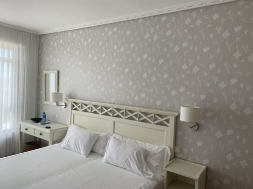 Habitación luminosa del Hotel Playa de Los Locos en Suances con cabecero crema, papel pintado floral y vistas al jardín
