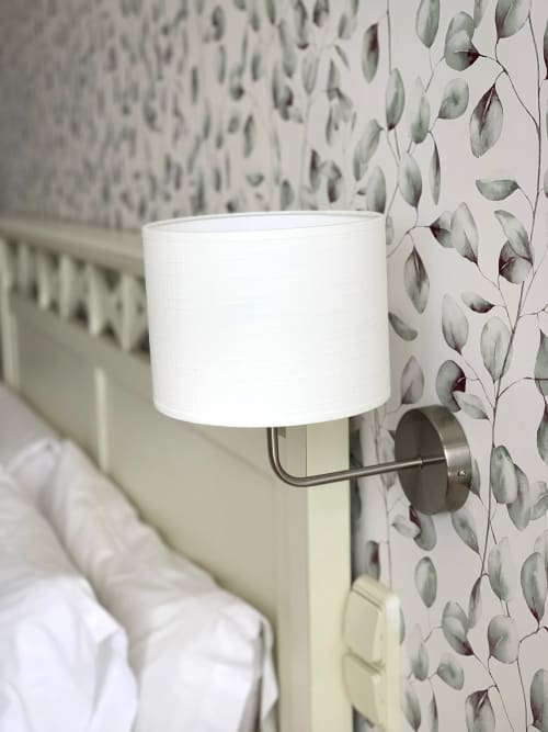 Aplique de pared moderno con pantalla blanca en dormitorio del Hotel Playa de Los Locos con papel tapiz botánico