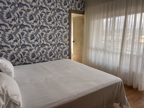 Habitación moderna con vistas al mar en Hotel Playa de Los Locos, Suances, con papel mural floral y cortinas semitransparentes.