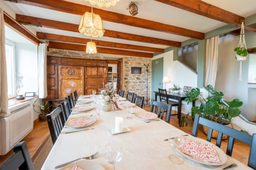 Salle à manger élégante du cottage Espace Ker Gana à Plourin avec poutres apparentes et table dressée