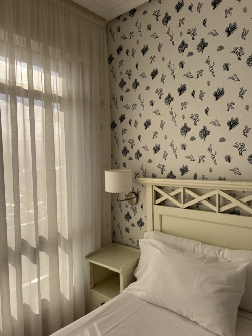 Habitación luminosa del Hotel Playa de Los Locos en Suances con papel tapiz botánico, ropa de cama blanca y ventana con vistas al mar