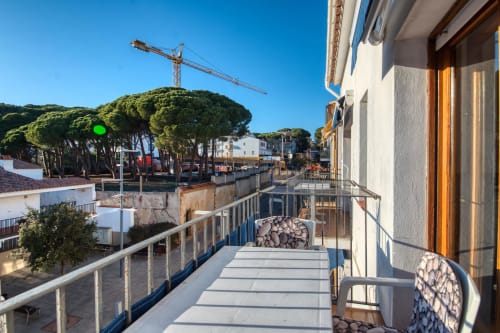 Balcony view of Palafrugell city with pine trees, construction crane, and Mediterranean architecture from Apt. Can Niell 2.