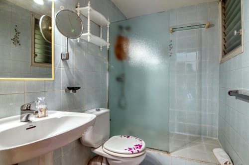 Modern bathroom with glass shower enclosure, white sink, and toilet at Finques Garcia Enrich apartment in Palafrugell, Spain