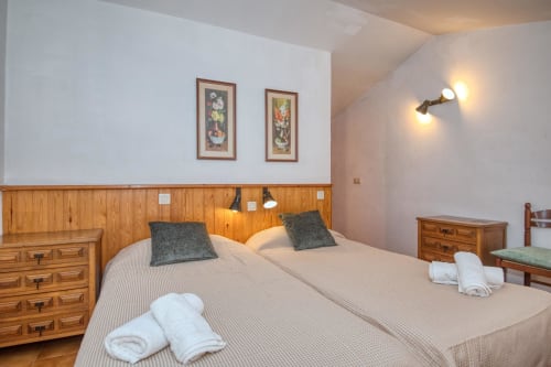 Modern bedroom at Finques Garcia Enrich apartment in Palafrugell with twin beds, wooden headboard, and city view