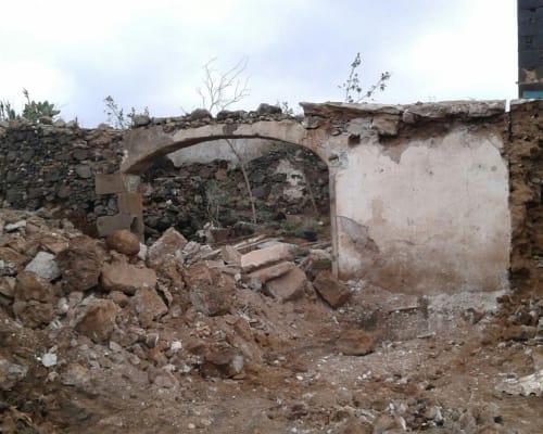 Ruins of abandoned stone building at Finca de La Geria, Yaiza, Spain with arched doorway and debris