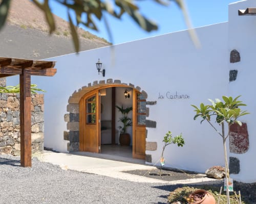 La Cachera entrance at Finca de La Geria hotel in Yaiza with white walls and wooden arched door