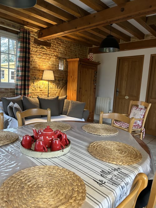 La salle à manger du Clos Mahiel avec ses poutres apparentes, ses murs en pierre rustique à Saint-Romain-de-Colbosc