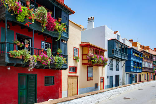 Edificios coloniales coloridos con balcones floridos en la calle adoquinada de Santa Cruz de la Palma, España