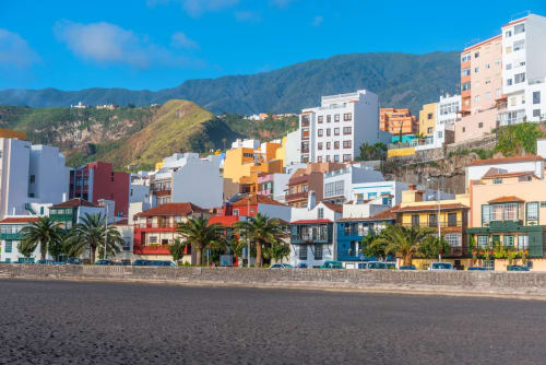 Coloridas construcciones frente al mar en Santa Cruz de la Palma con backdrop de montañas