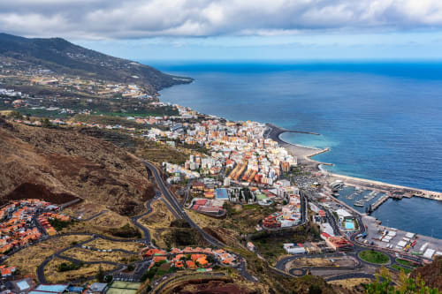 Vista aérea de Santa Cruz de la Palma con océano azul, montañas y desarrollo costero